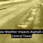 Damaged asphalt road with multiple potholes and puddles, illustrating how weather impacts asphalt surfaces in Central Texas.